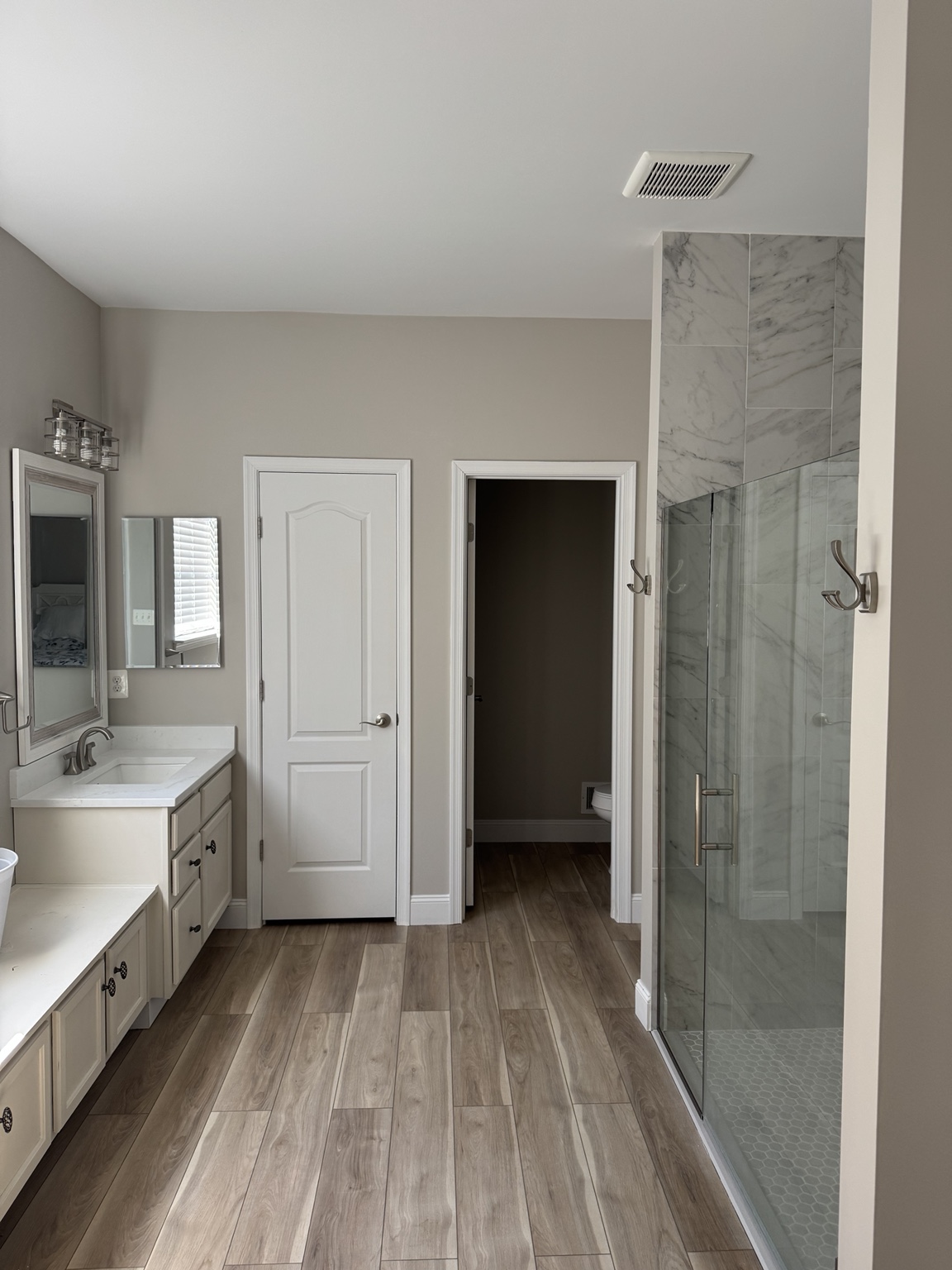Completed bathroom with a double vanity and glass shower enclosure